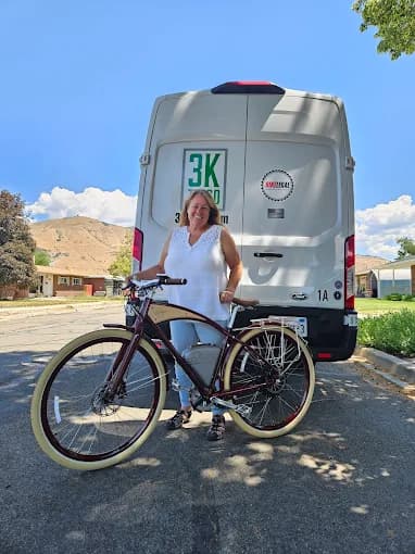 Customer with their new e-bike beside the branded 3KtoGO delivery and service van